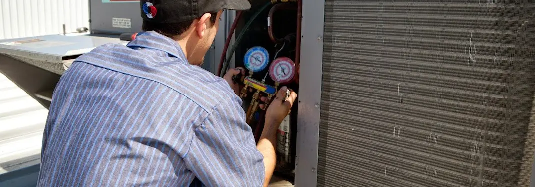 HVAC technician servicing a condenser unit in Nottingham