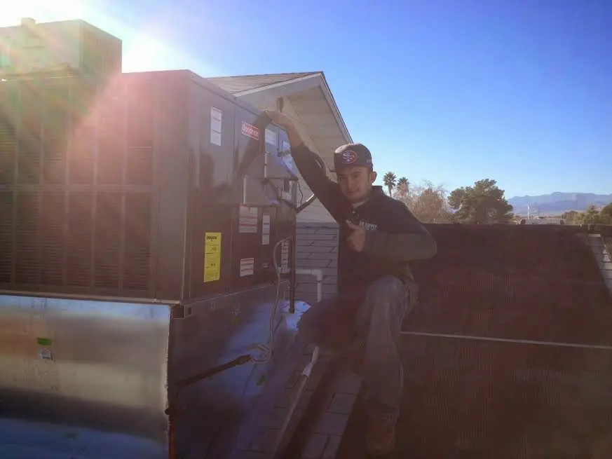 HVAC technician performing HVAC Inspection on a rooftop unit in Nottingham